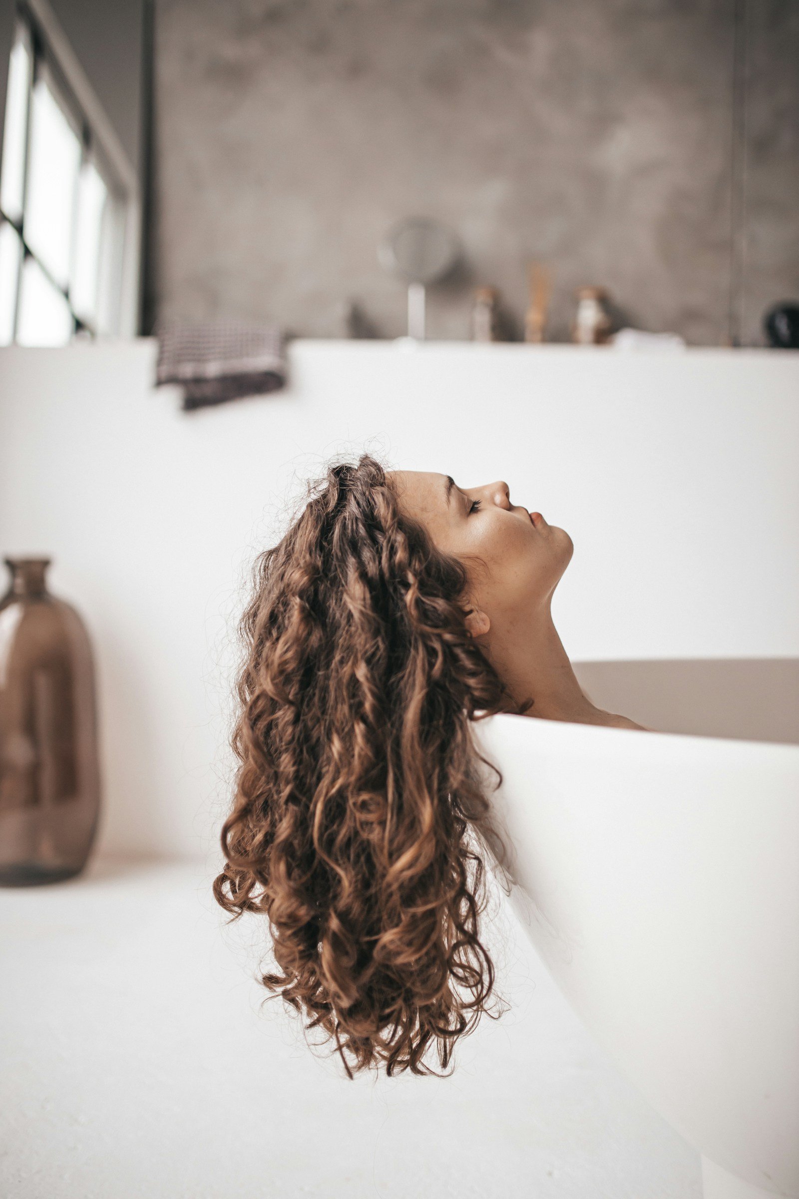 Curly hair being combed through during a morning bathroom routine